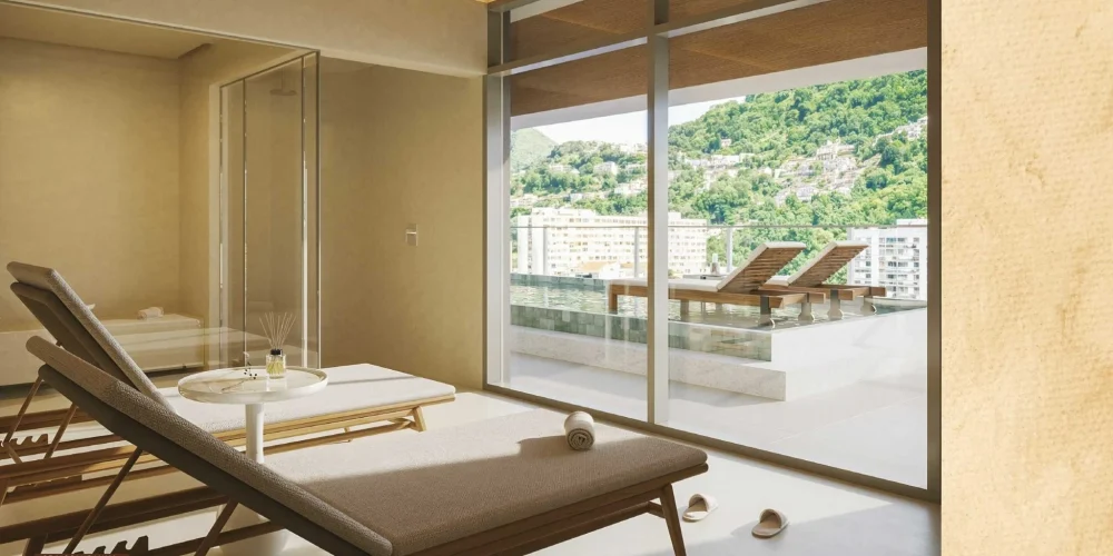 Área de spa com sauna e espreguiçadeiras do Céu Laranjeiras, com vista para o verde e ambiente de bem-estar e relaxamento.