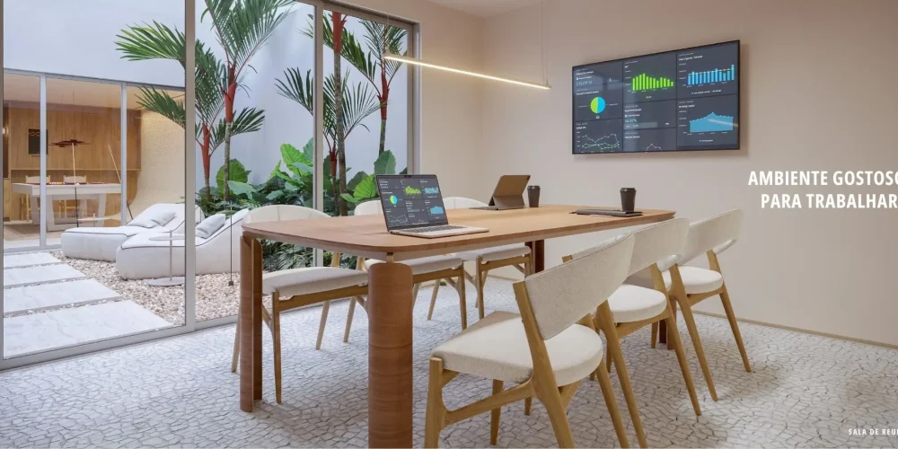 Sala de reunião do Sal Praia Ipanema com mesa de madeira, cadeiras claras, área verde externa e ambiente moderno para trabalho.